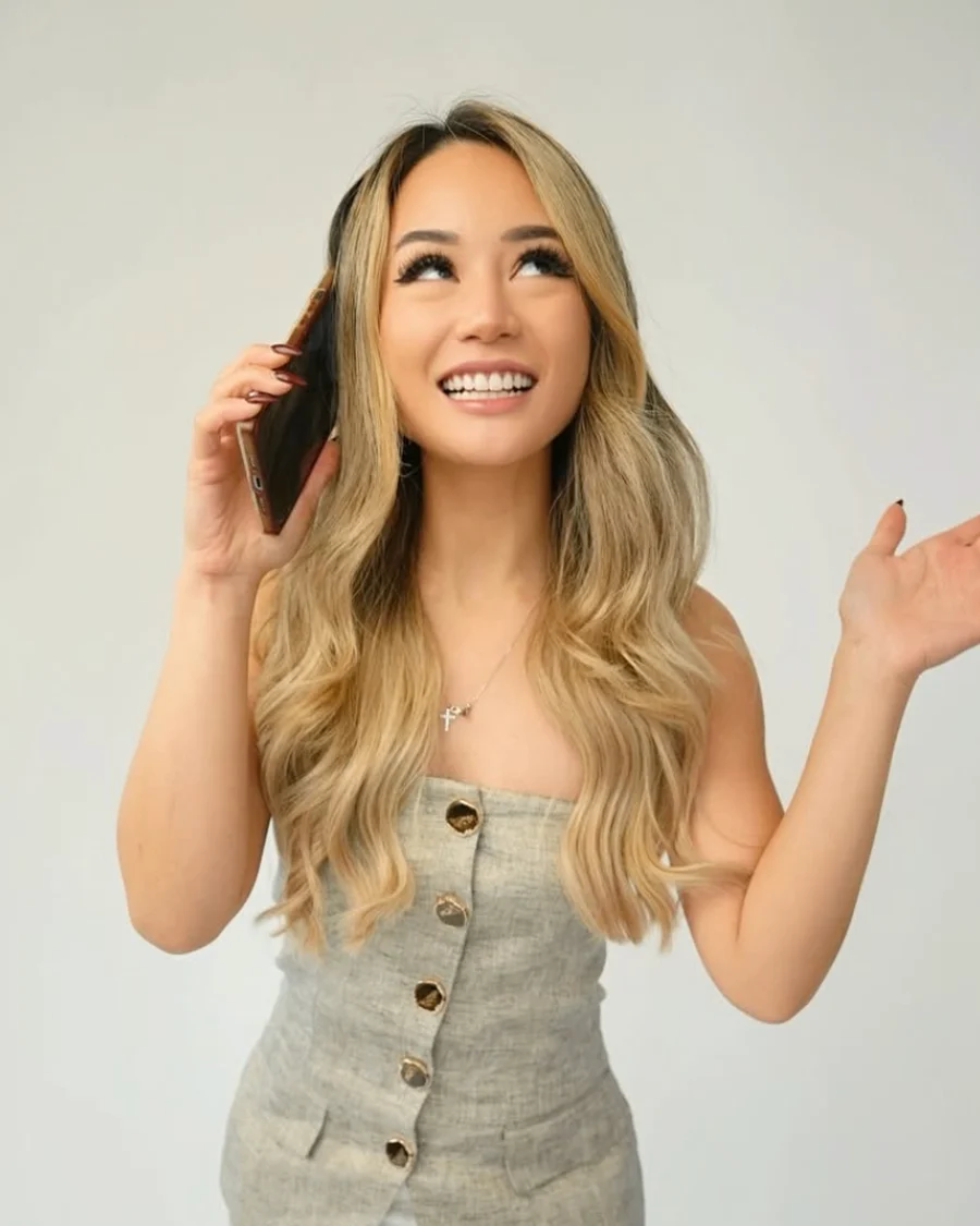 Tawny Noelle smiling, phone to her ear, in the studio