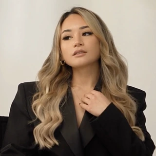 Tawny Noelle in a black blazer, seated in a director's chair at the studio