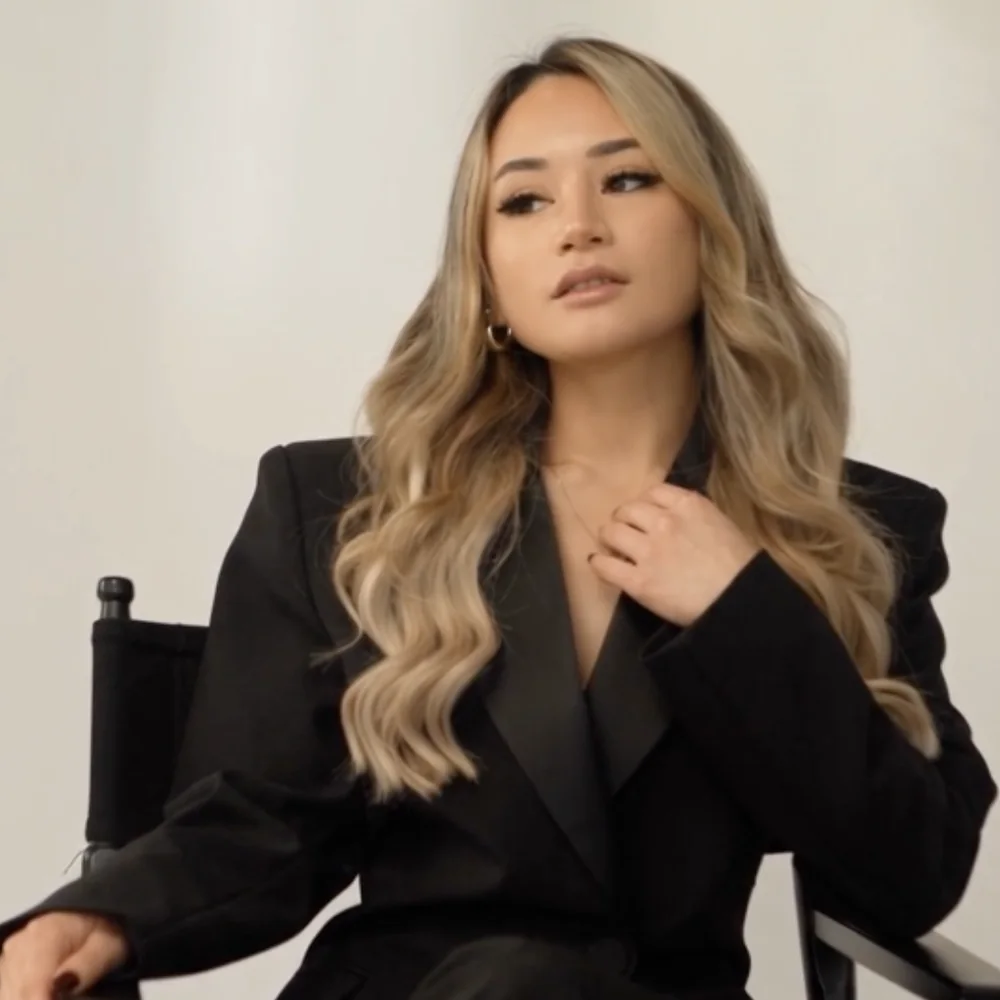 Tawny Noelle in a black blazer, seated in a director's chair at the studio
